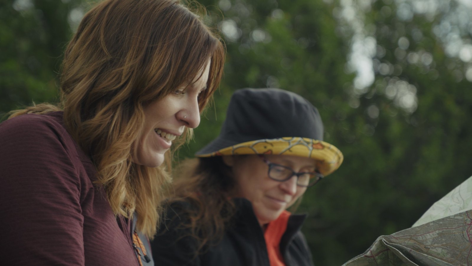 Two women reading a folded map together outdoors