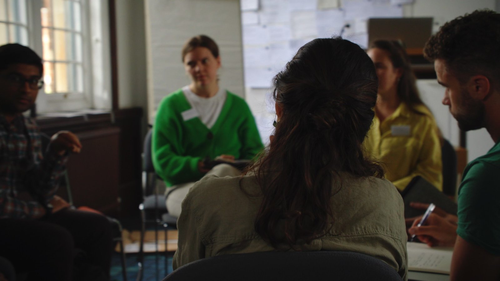 A small group sitting in a circle during a workshop discussion