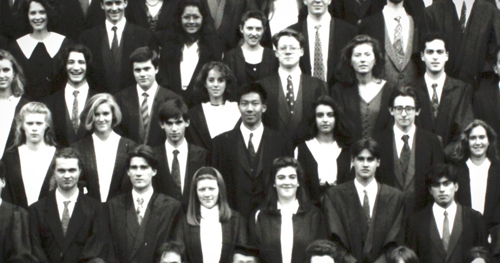 Black-and-white group photograph of students in academic gowns